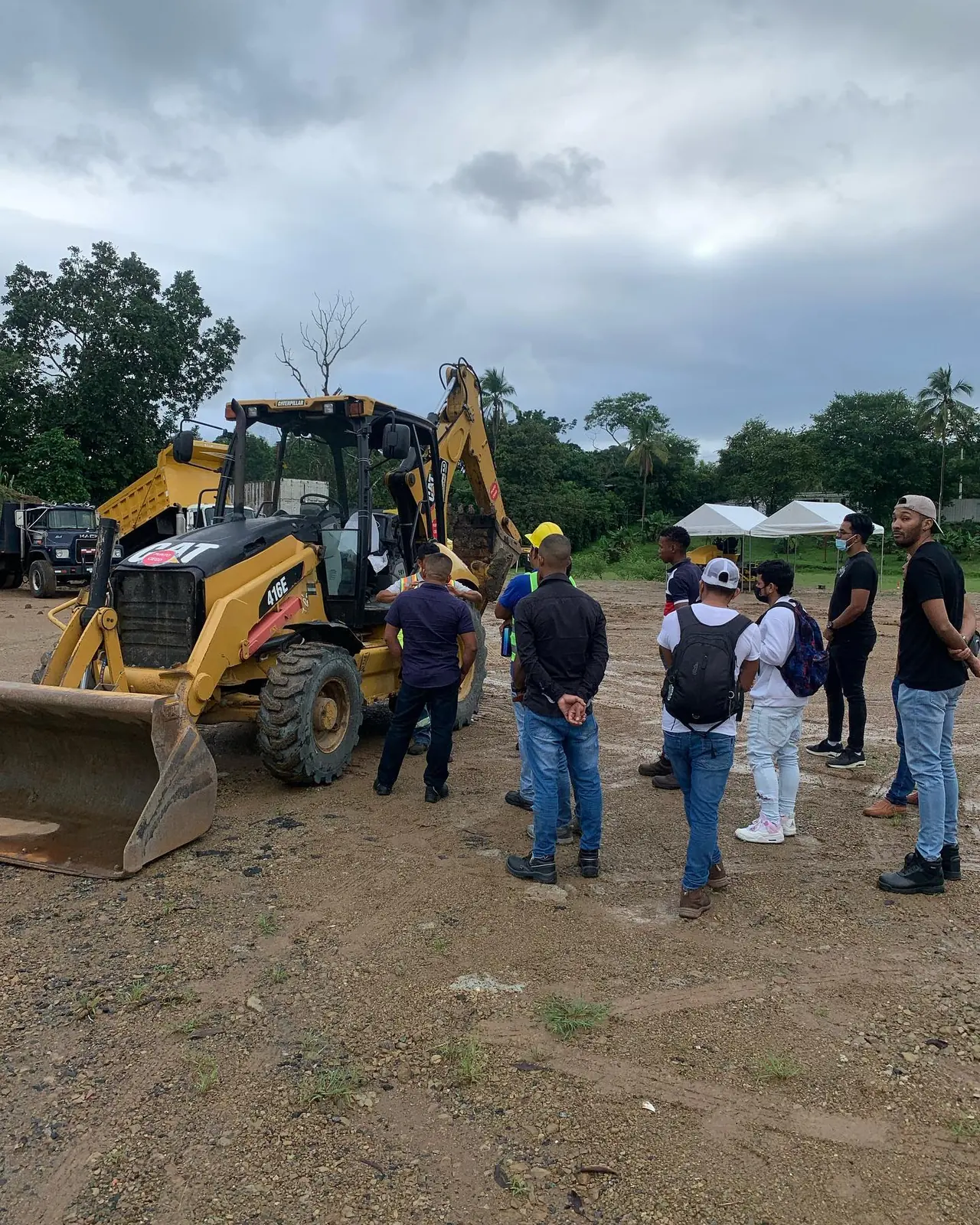 Inducción de operadores junto a una retroexcavadora Caterpillar 416E.